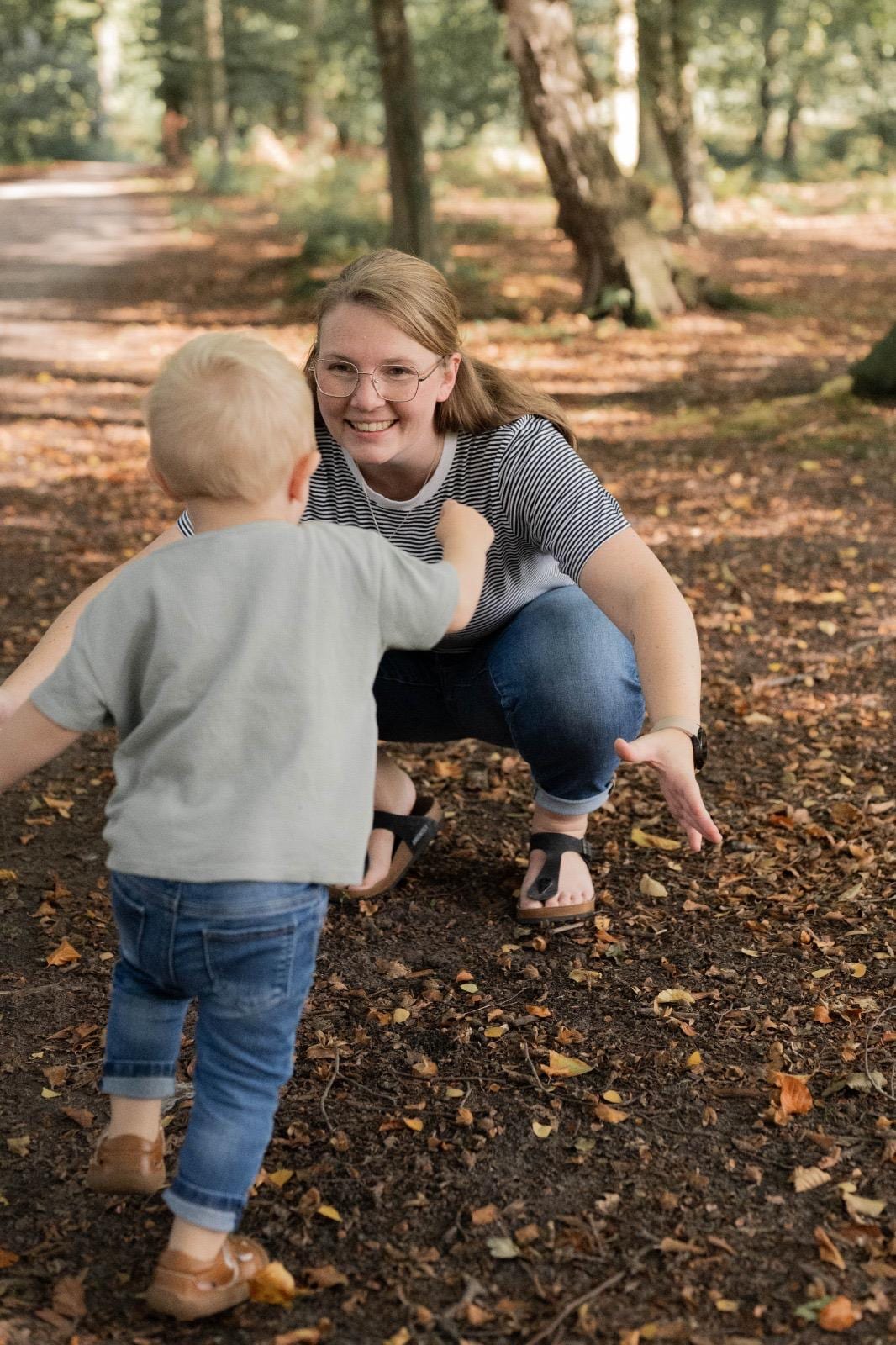 Kleinkind läuft im Wald zu seiner Mama