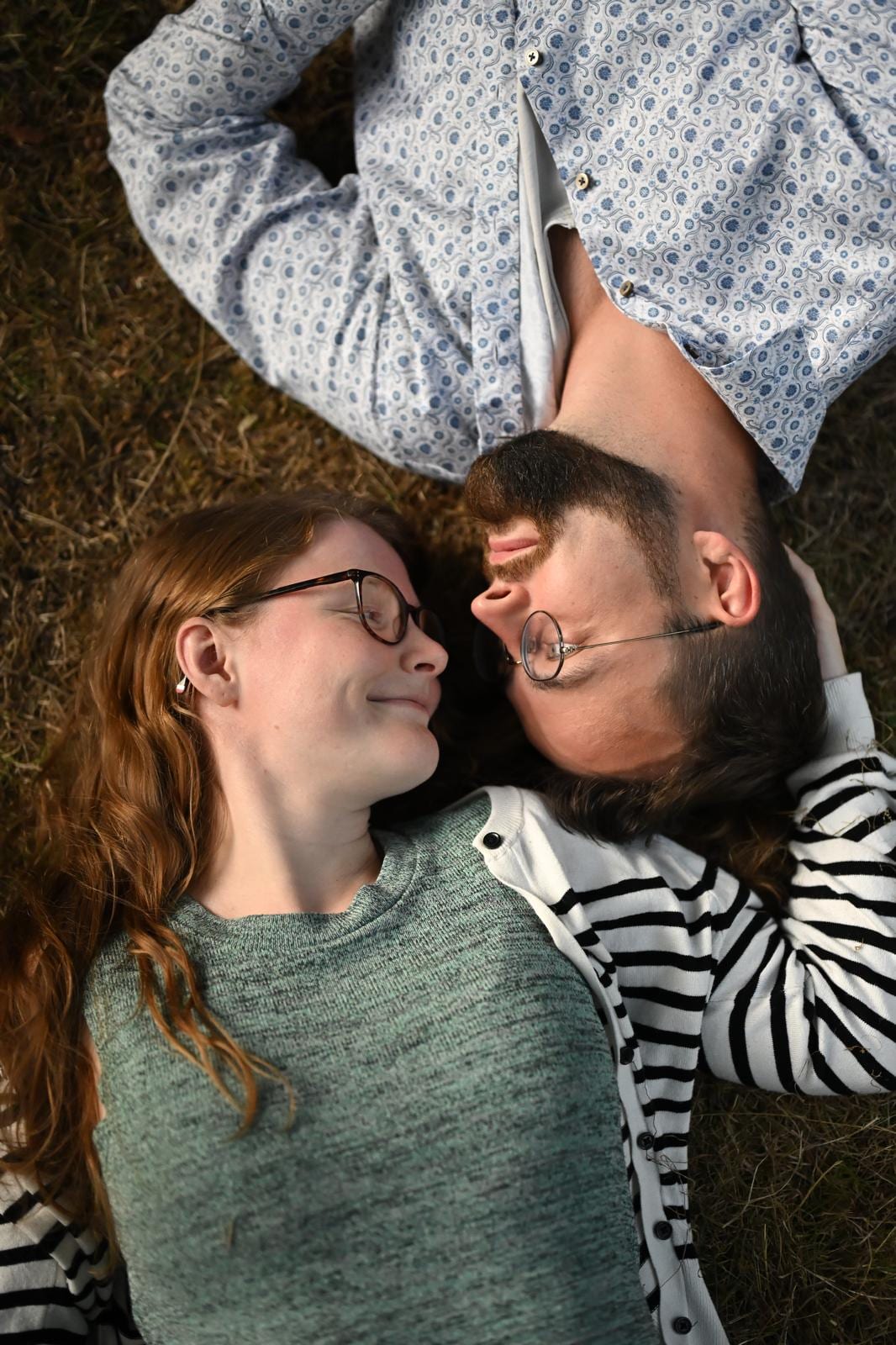 Paar liegt lachend im Gras